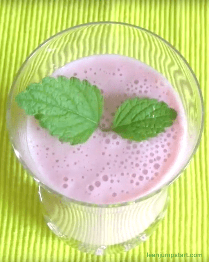 strawberry banana smoothie with lemon balm leave top view
