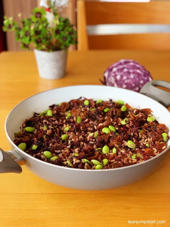 a colorful one-pan meal with red cabbage blurred in the background