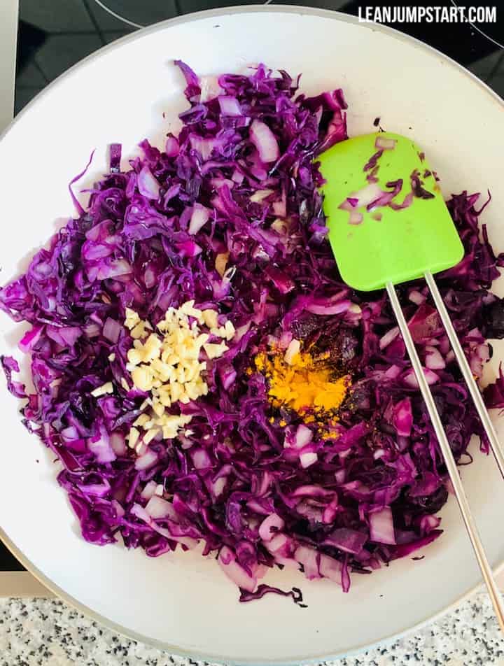 stir-fry with added garlic and turmeric stirring with a green spatula